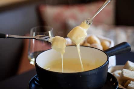 Schwarzer Fondue-Caquelon mit zwei Gabeln