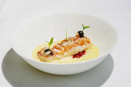 Garden Party 2022, Grand Resort Bad Ragaz, SG, Peter Knogl, Cheval Blanc, Rotbarbenfilet mit Safran-Sauce, fermentiertem Knoblauch und Tomatenvinaigrette Gericht: Knogl-Klassiker: Rotbarbe mit frittierten Schuppen, Safran-Sauce, fermentiertem Knoblauch und Tomatenvinaigrette.