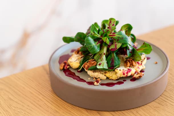 Grillierter Blumenkohl mit Randen-Dressing Blumenkohl-Steak vom Big Green Egg mit Nüsslisalat und Randen-Dressing - Kempinski Palace Engelberg Titlis - Michele Müller, Küchenchef - 14. Januar 2022 - Copyright Olivia Pulver