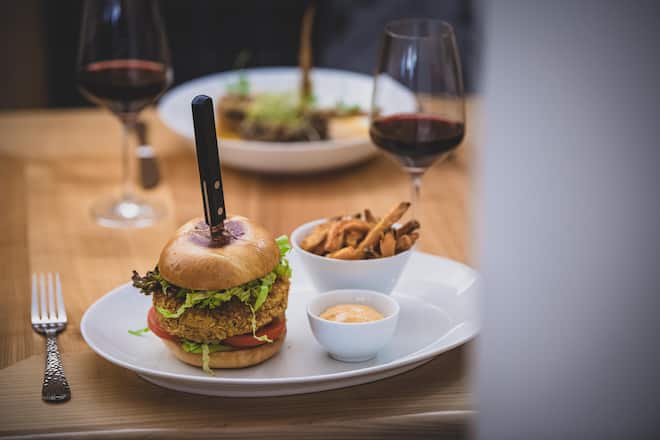 Veganer Hirse Burger; veganes Brioche, Hirse Burger, vegane Mayo, Kopfsalat, Tomaten in Scheiben, Salatgurke, Rotezwiebel Ringe, Adula Burger, Restaurant La Clav, Vegetarisch, La CLav, Hotel Adula, Chefkoch Thomas Huber, Adula, Flims © Dani Ammann