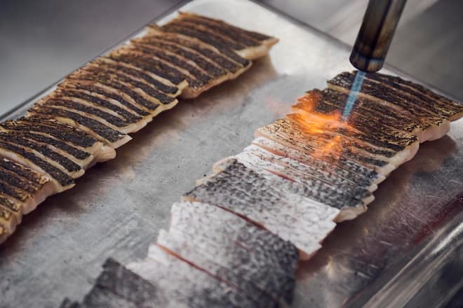 Légèrement passées au chalumeau, les tranches de poisson acquièrent un goût subtil.