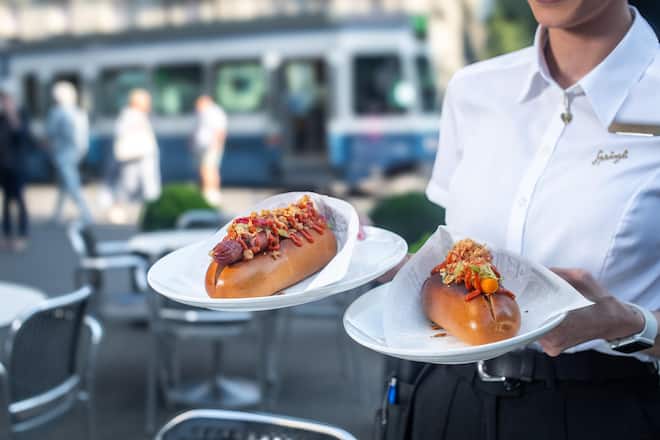 Sprüngli Hot Dog Rindswurst, Brioche, Coleslaw, Apfel-Sellerie, Röstzwiebeln und Smoking Gun Sauce Sprüngli Rüebli Dog Sous-vide Rüebli, Brioche, Coleslaw, Apfel-Sellerie, Röstzwiebeln und Smoking Gun Sauce