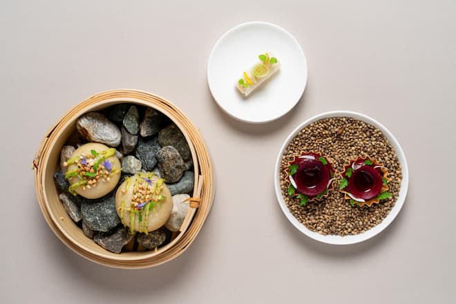 Bao-Buns gefüllt mit Kalbsschwanz und Gersten Miso, darauf Miso-Koriander Mayonnaise und gepuffter Buchweizen; Rauchranden Tartelette mit Walliser Eringer Beeftartar; Rettich Rolle mit Alpenzander Ceviche und Salzzitrone Pressebilder The Omnia Zermatt