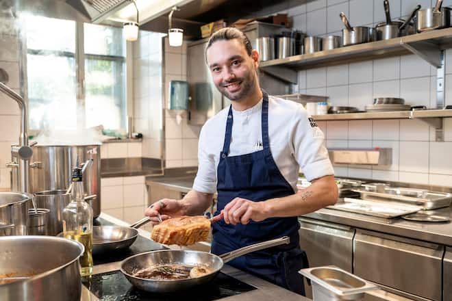 Chefkoch Lorenz Kaiser am Zubereiten des Schweinskotelett mit Café de Paris und Jus