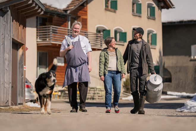 Besuch im Restaurant Bachhuus in Hinterrhein (Graubuenden) fuer GaultMillau. Carelia Joos, Thomas Egger und Torsten Roenisch (li) mit Huendin Maira fotografiert am 20. Maerz 2026. Bild Yanik Buerkli