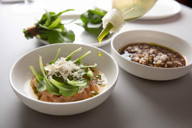 Teller die zusammengehören: Winterlicher Kräuterstrauss mit Apfelleder dazu Pilzfond mit Apfelsaft, Pilz-Brunoise und Schnittlauch-öl.Teller daneben: Fermentierte Birne, in Soja gebeiztes Eigelb, Nüsslisalat und Meerrettich.