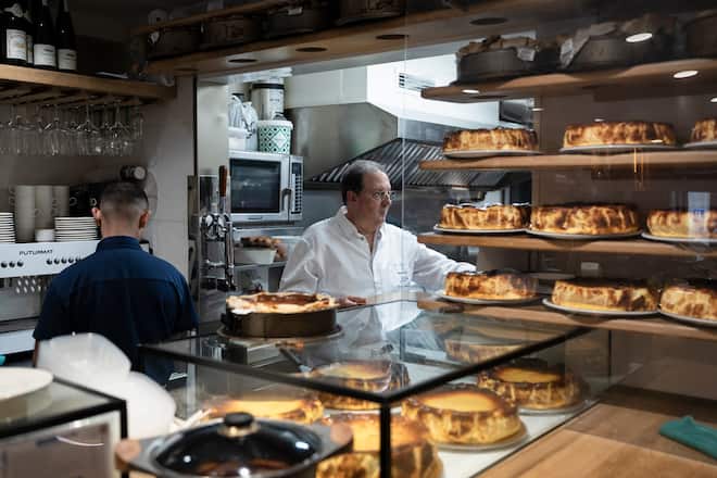 Santiago Rivera, center, works at the counter at his restaurant, La Viña, in San Sebastián, Spain, May 14, 2026. Rivera is widely credited with creating the "burnt" Basque cheesecake in the 1980s, though he doesn't love the spinoffs it has spawned. Decades later, he's preparing to hand over his kitchen to his children. (Markel Redondo/The New York Times)