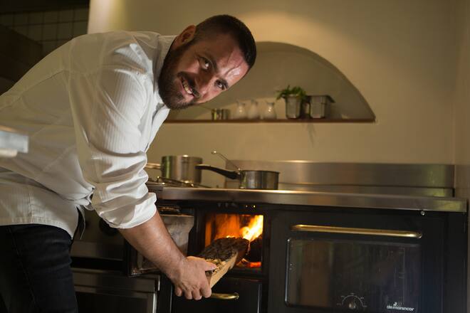 Romaine Paillerau am Holzherd in der Küche.