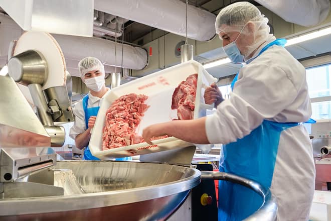 Antonio und Betim zerkleinern das magere Fleisch.