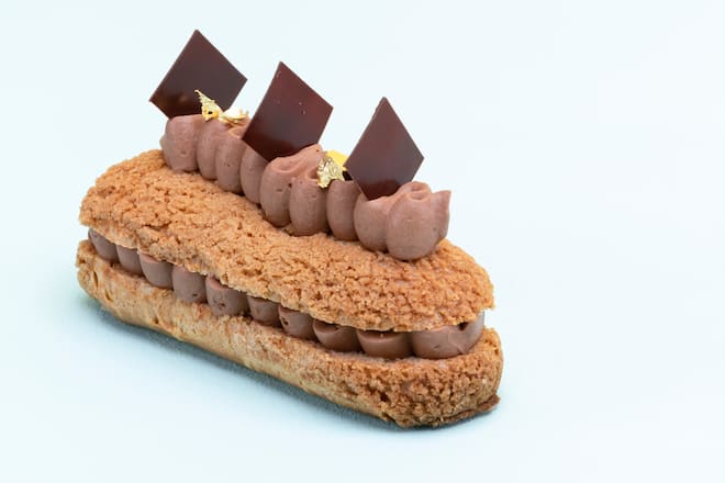 Schokoladen-Éclair auf Hallblauem Hintergrund