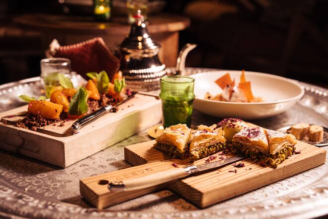 Zum Baklava gibts ein Pistache-Glace und Rosenblüten. BurtuqÄl ist ein Dessert aus Orangen, Felchlins-Schokolade, Mandelnt, Pfefferminz und Orangensirup. Und Naryla besteht aus einem Kokosnusssorbet, Kokos-Crumble, Limmeten-Gel und Ingwer. - Cervo - Zermatt Tourismus - Tapas Tour - 07/2023 - Copyright Olivia Pulver