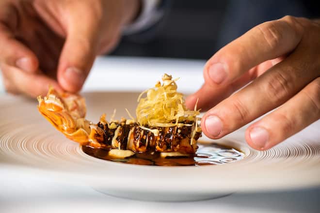 Benoit Carcenat, Restaurant Valrose 2022: Frittierte Langoustine mit Krustentieröl, Langoustinenjus, Kakaoöl, Kakao-Gel, Artischockenpüree, Artischockensalat, japanischer Buchweizenknusper, hausgemachte Buchweizensprossen