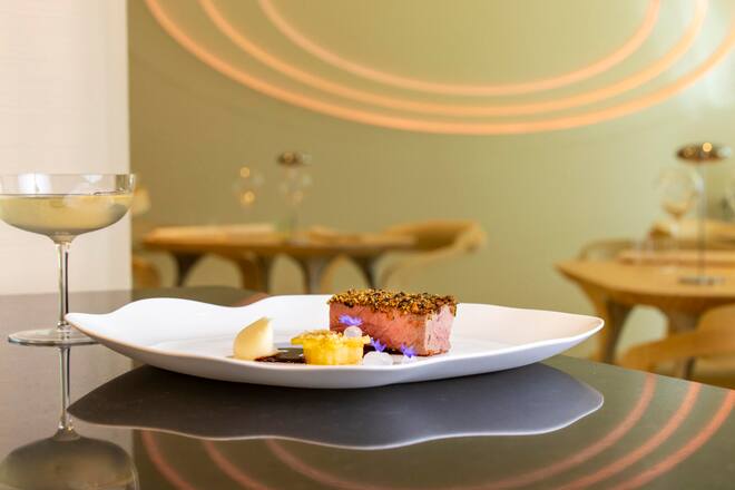 Fleischgang Hohrücken-Steak von dem Piemonteser Rind mit Kruste (Kruste aus Kartoffeln, getrocknete nChampignons, kandierten Oliven, Stangensellerie, fermentierten Haselnüssen) Dazu Sellerie-Mousseline eingelegte Ãpfel als Kranz Lavendel-Gel .Restaurant CAAA, Pietro Catalano, Luzern. Aufgenommen am 30.04.2024 ©David Birri