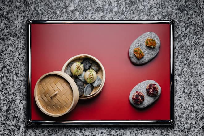 Amuse-Bouche-Reigen à la «Omnia» Bao-Buns mit Rind, Tacos mit Lachs und Kürbis, Tartelettes mit Steinbock- Tatar und Quitte, Küchenchef André Kneubühler THE OMNIA. 17. Oktober 2025, THE OMNIA, Auf dem Fels, 3920 Zermatt, Copyright Roy Matter Titelstory GM-Magazin 4/25 André Kneubühler The Omnia Zermatt