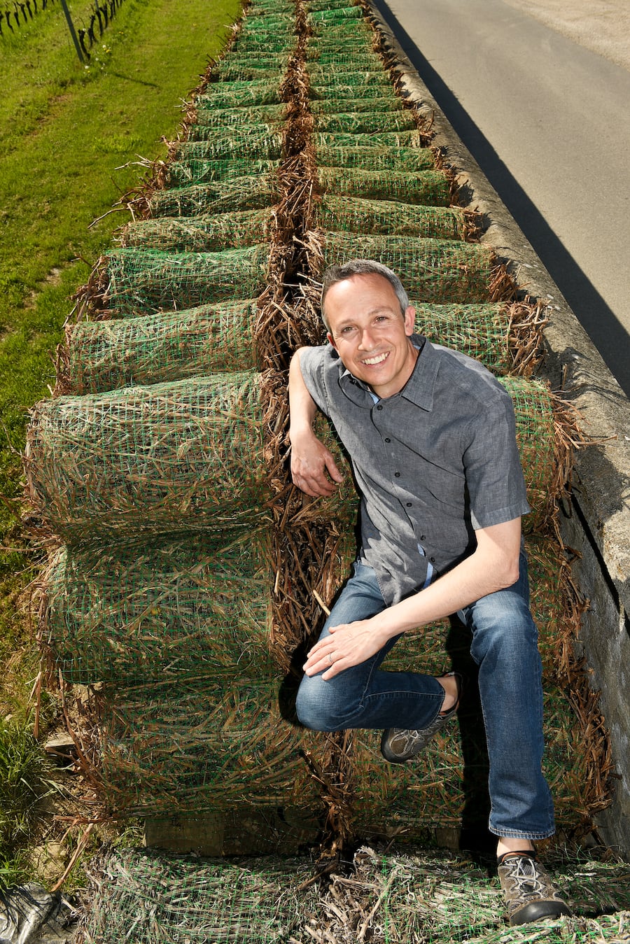 Portrait de Denis Hermanjat sur des fagots de sarments retirés des vignes.