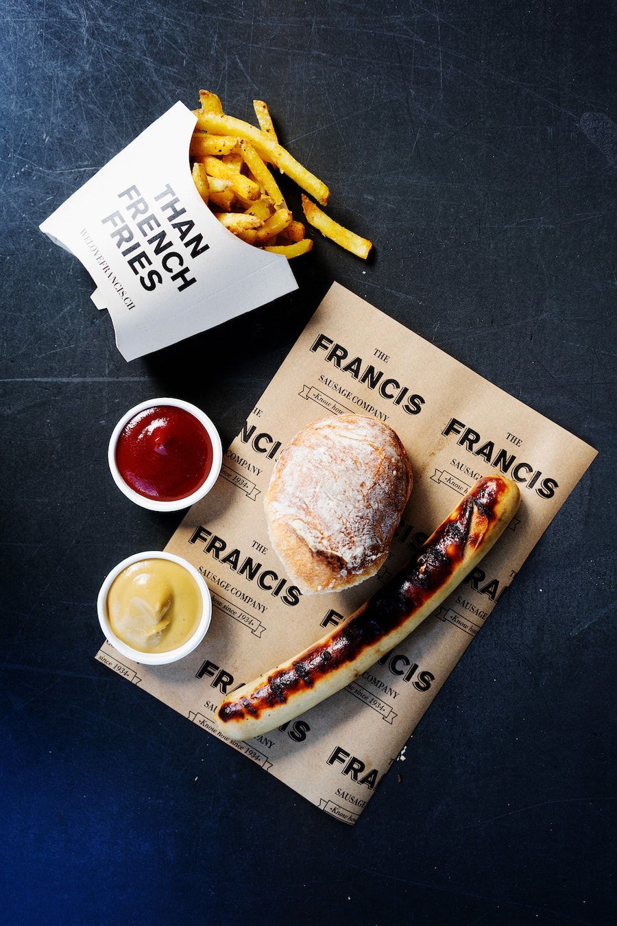 Kalbsbratwurst und Pommes frites bei Francis Sausage Company in Zürich vor dem Globus