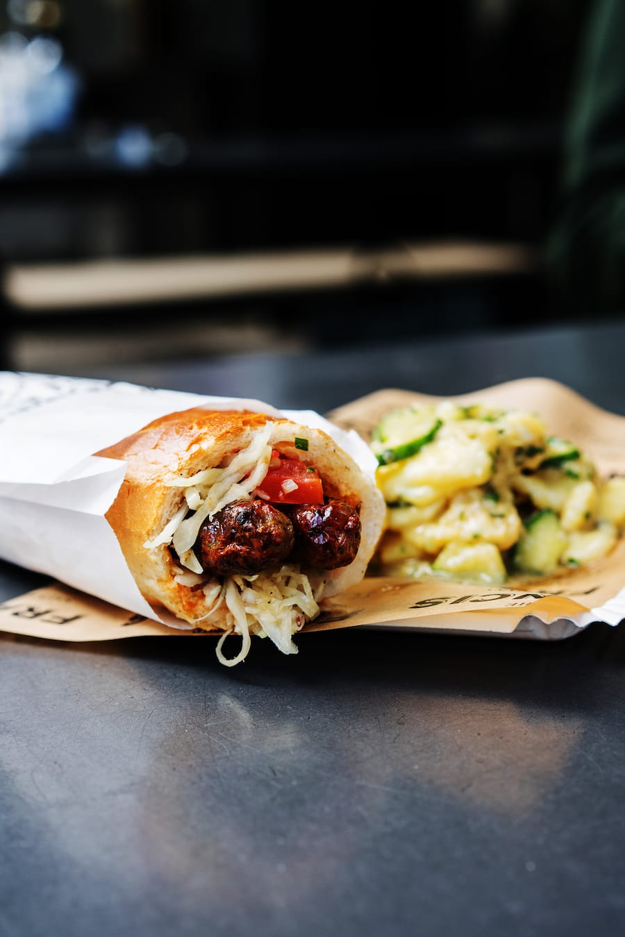 Stuffed Dog und Kartoffelsalat bei Francis Sausage Company in Zürich vor dem Globus