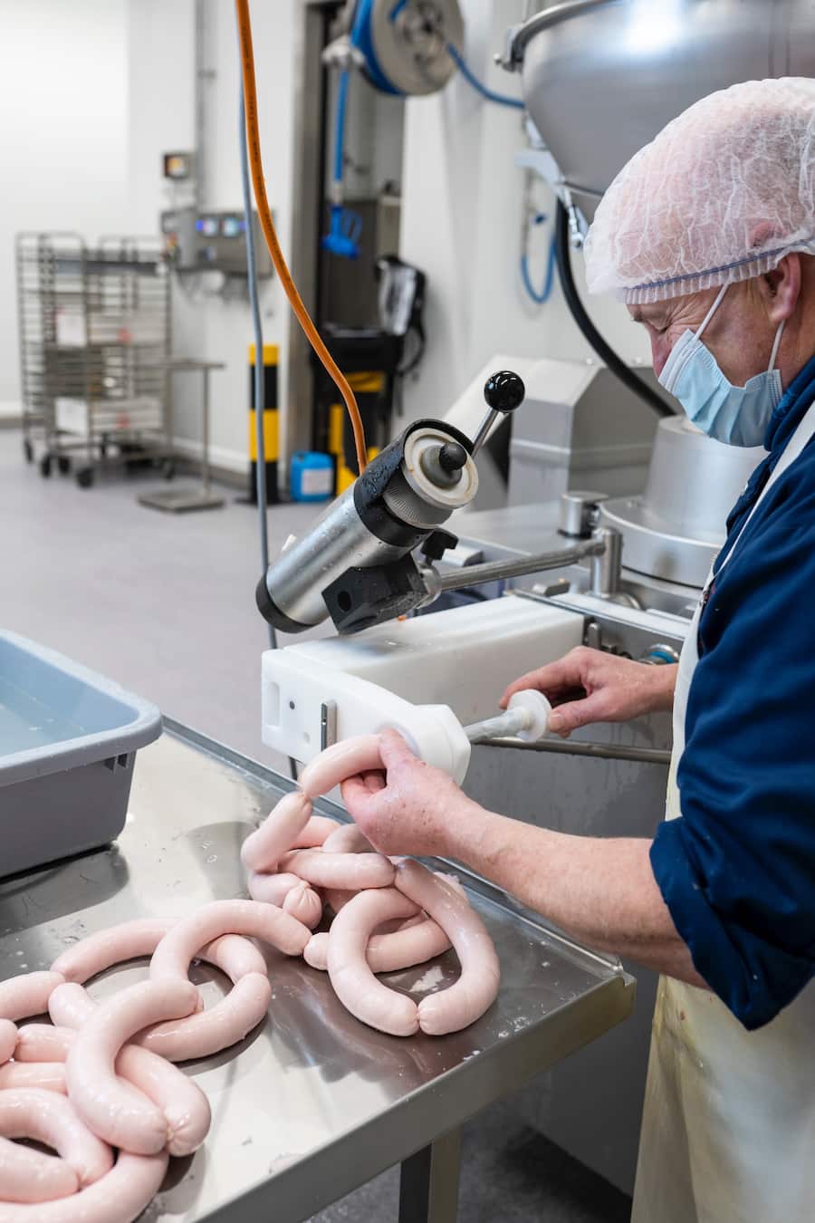 Bianchi, neue Fleischfabrik, in Zufikon, Hansruedi Bossert am Wursten von Bianchi-Kalbsbratwürsten