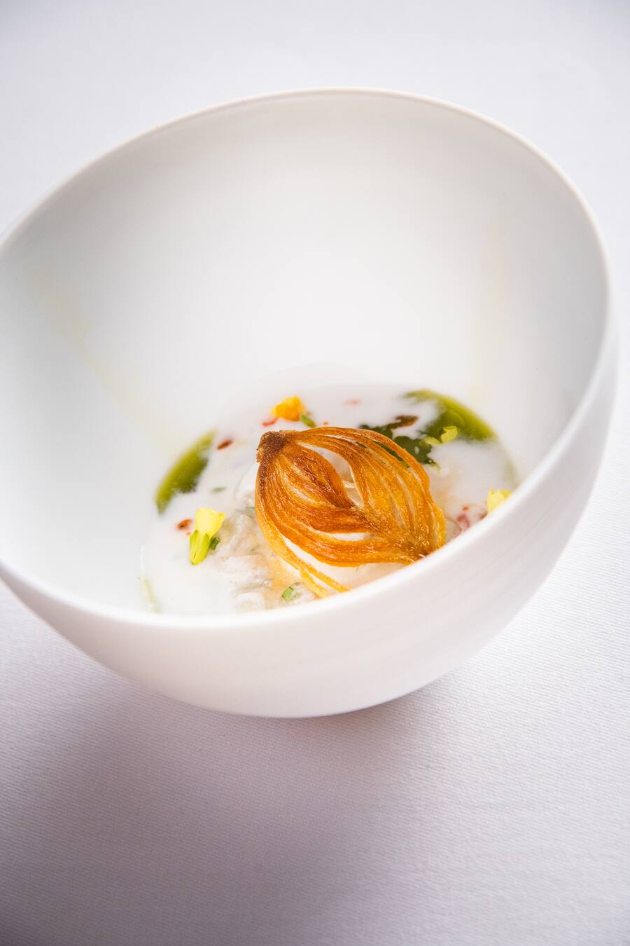 Andreas Caminada kocht mit Gaggan Anand 2018:Hakobsmuschel mit Chili- und Curryöl, Kokosnuss und frittierte Zwiebel