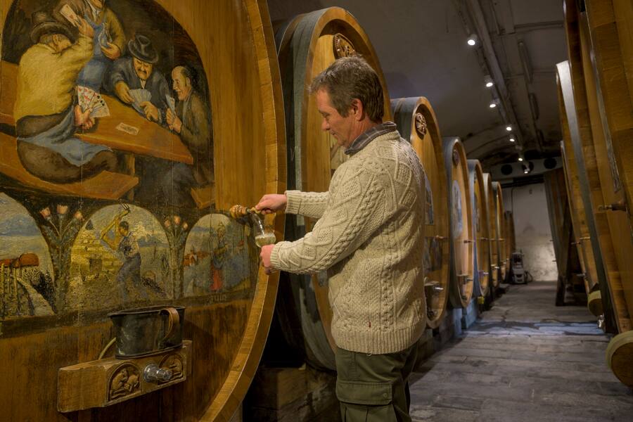 Eric Bovy ist für zuständig für Weine und Reben . Holzfasskeller mit Malereien von Maurice Bovy