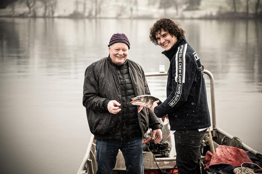 Dominic Bürli 2021: Fischer Theodor Zimmermann fischt mit Dominic eine Forelle aus dem Zugersee.