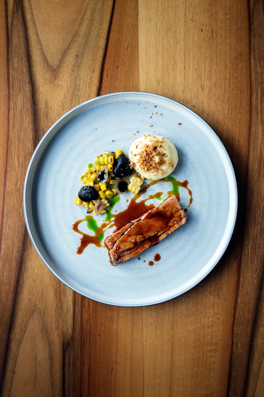 Butterzarter Kalbshals an einem dichten Kalbsjus mit grilliertem Mais, luftigem Kartoffelschaum, eingelegten Zwiebeln, Schnittlauch-Öl und fermentierte Shiitake im Restaurant EquiTable von Fabian Fuchs in Zürich