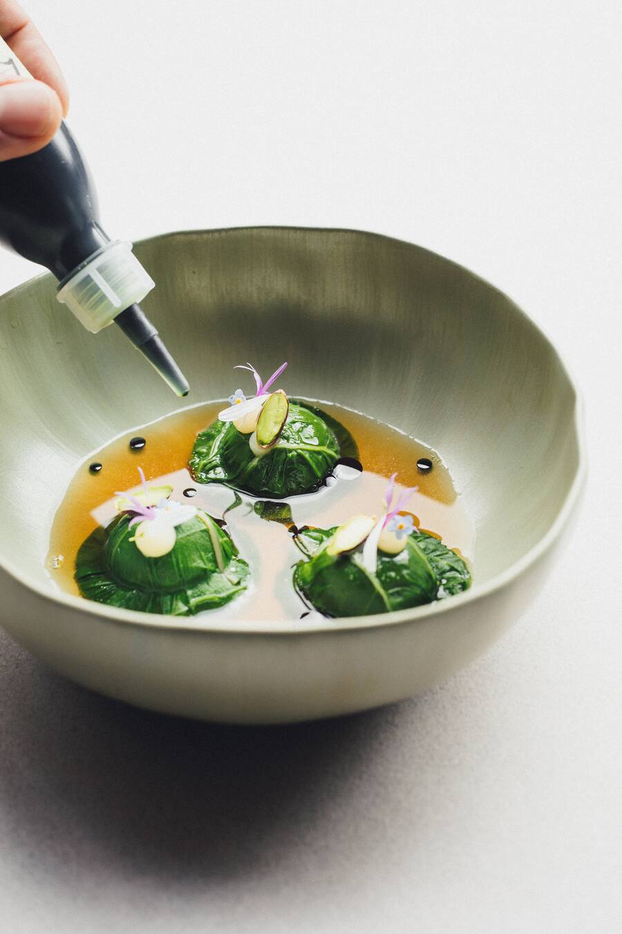 Hotel Vals 7132, Restaurant Silver, Chefkoch Mitja Birlo,Mangoldravioli, geröstete Mangoldcreme, Pistazien, Fond aus Valser Entenkarkassen und Bärlauchöl, Salzzitronencreme,Foto: Digitale Massarbeit, Tanja und Simon Kurt