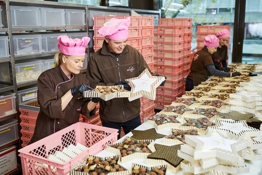 Juliana Bachmann und Almir Kumalic, Leiter Verpackung, in der Abteilung Verpackung (beim Ãberprüfen der Schutzängeli). Thema Pralinen. Confiserie Bachmann, Luzern, 25.11.2020, Foto Lucia Hunziker