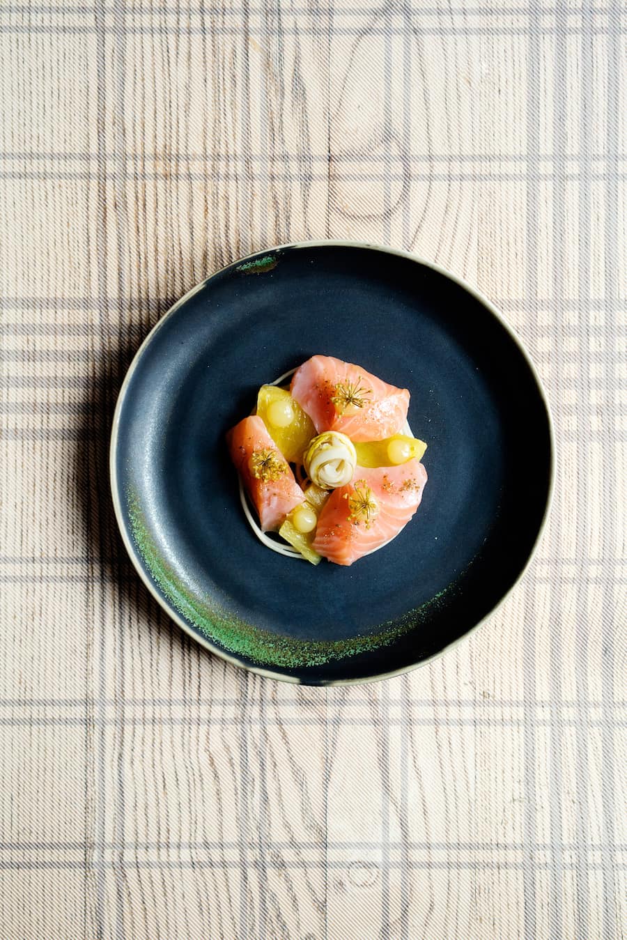 Eine feinsinnige Kombination: leicht gebeizte Lachsfilets, eingelegte Fenchelblüten und in Salz gebackener Ananas im Maison Manesse in Zürich