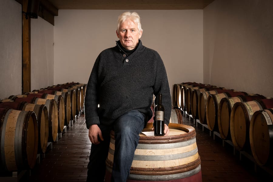 Le vigneron Christian Dugon pose dans sa cave, le mardi 15 février 2022 à Bofflens. (© Gabriel Monnet/ Gault & Millau)