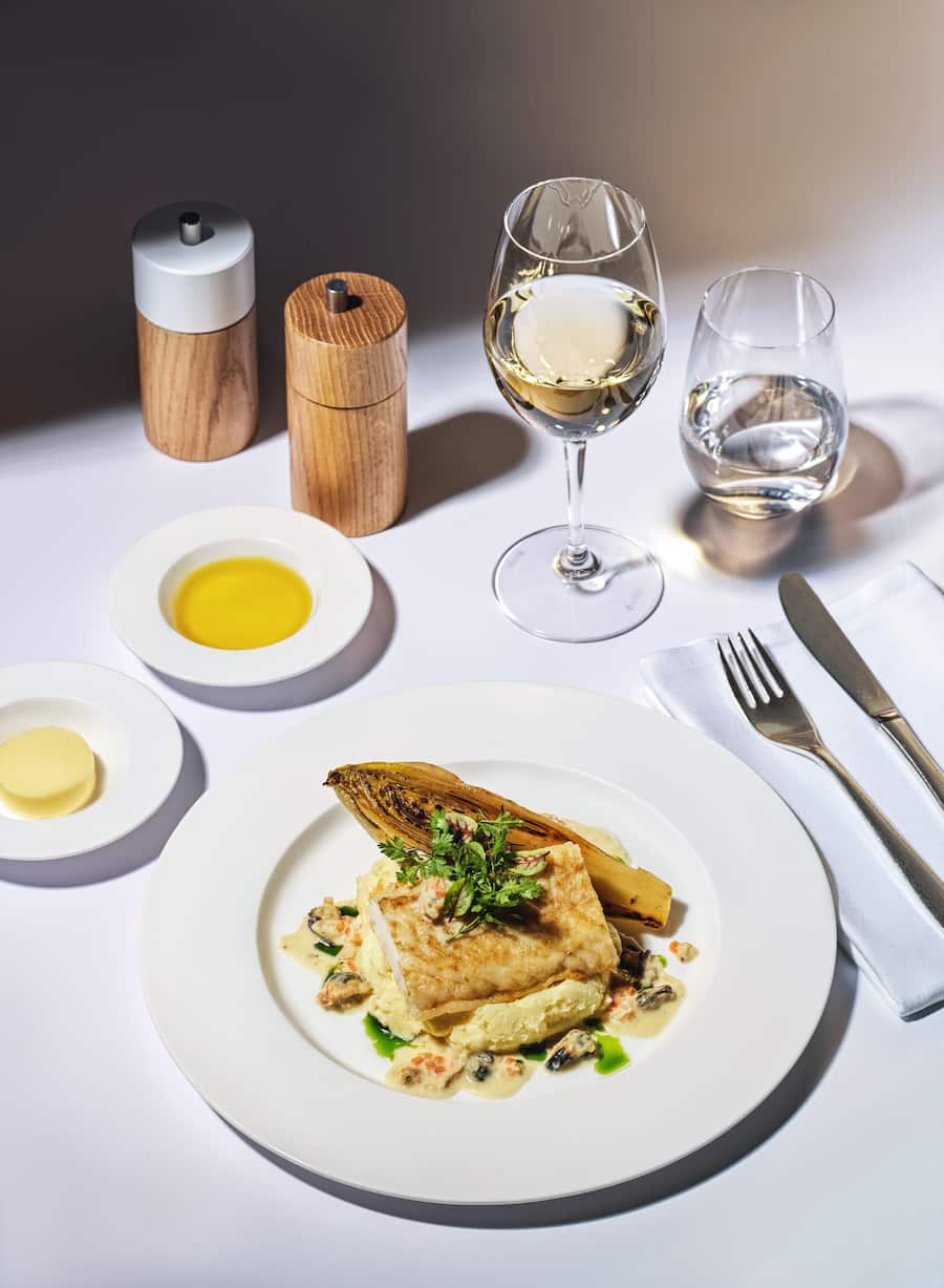 SWISS Food an Bord von Küchenchef Patrick Mahler 2022 Dorschfilet mit Muschel-Beurre-blanc Kartoffel-Zitronen-Mousseline mit Chicorée