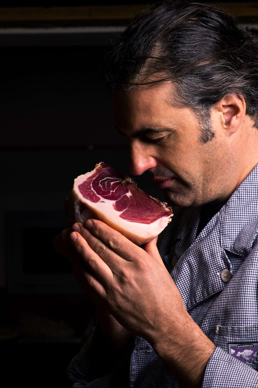 Bauernhof Zur chalte Hose, Claudia Wanger und Nils Müller. Nils Müller riecht am Culatello, der 24 Monate gereift ist.