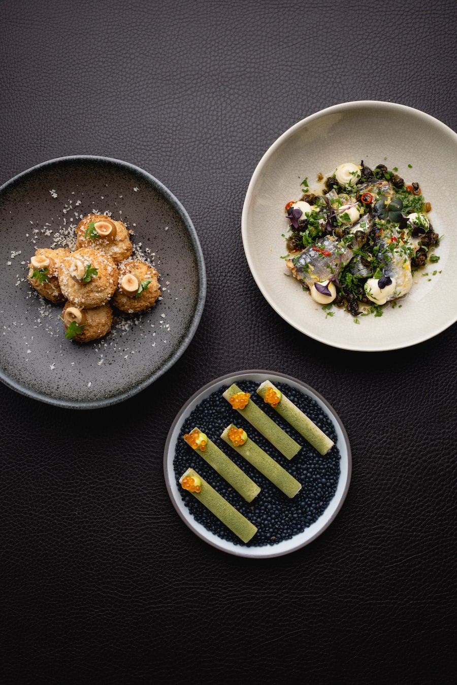Repas, Biel, Snack-Trio, geräucherte Forellen-Zigarren, Jahrgangssardinen mit frittierten Kapern, Haselnuss-Gougeres mit Roquefort und Birne