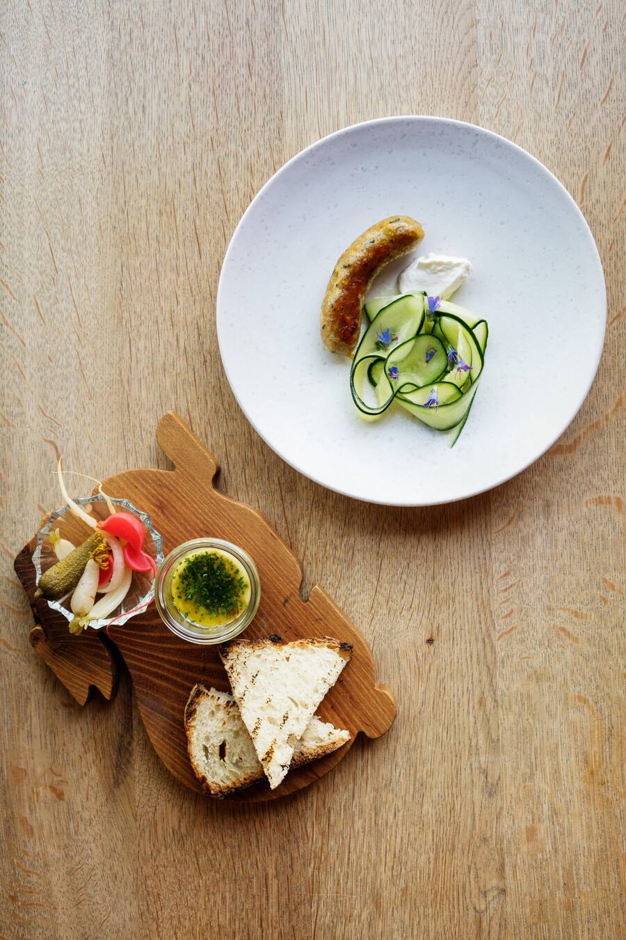 Restaurant Metzg in Zürich: Hausgemachtes Safran-Wurst mit Gurkensalat und griechischem Joghurt / Wollensau-Rilette, Pickles und geröstetes Brot