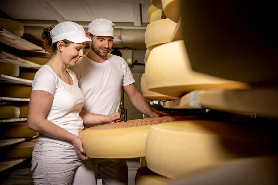 Lehrmeister Roland Meier. Zwei Generationen, ein Käse: Treffen zwischen Urs Schluechter, Direktor Emmentaler Switzerland, und Aline Hadorn, Lernende/Milchtechnologin in Kirchberg BE. Aufgenommen am 04.04.2023