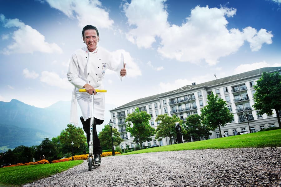 Renato Wüst, Executive Chef im Grand Resort Bad Ragaz fährt auf einem Trotinett
