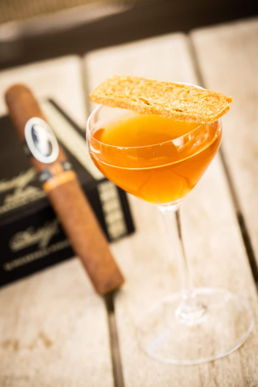 Davidoff-Zigarre und ein orangefarbener Cocktail im Vordergrund