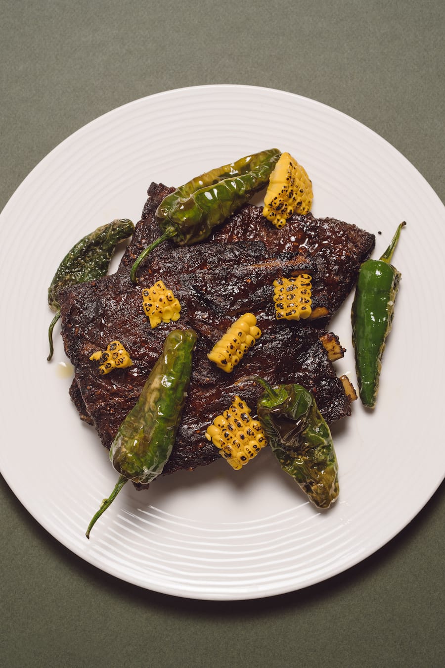 Spareribs vom Pata Negra Schwein (Luma) mit Pimientos de Padron und Mais - Fabio Lombardi (Küchenchef Rosaly's Zuerich) bereitet verschiedene Stücke von Luma Delikatessen zu - 06/2023 - Copyright Olivia Pulver