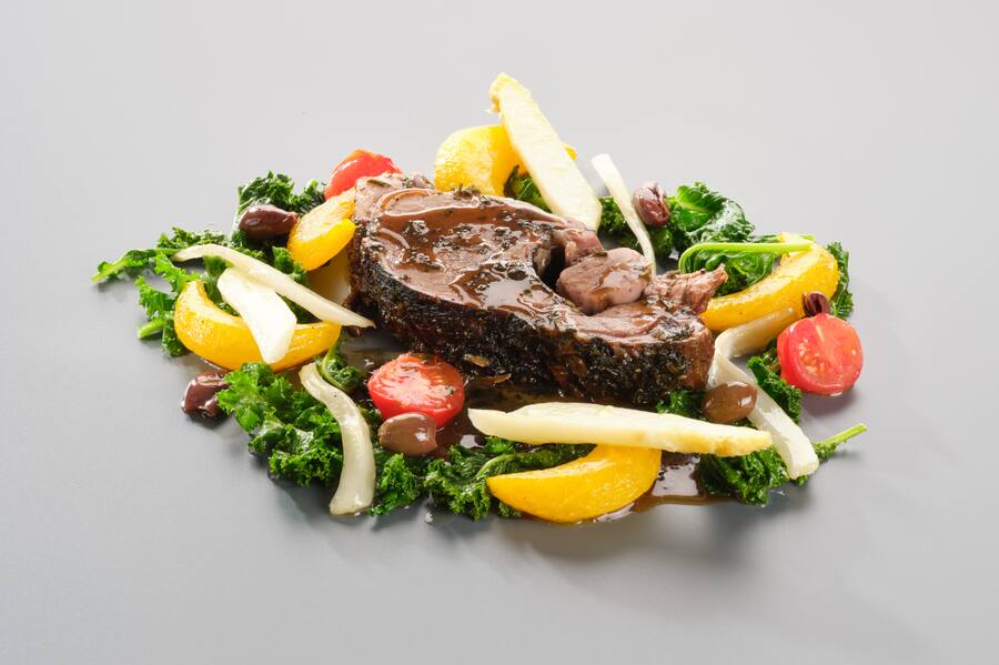 Geschmorte Schulter vom Surselva Lamm mit Gartenkräutern Federkohl, Kohlraben, Fenchel, Rheintaler Spargel und Taggiasca Oliven.