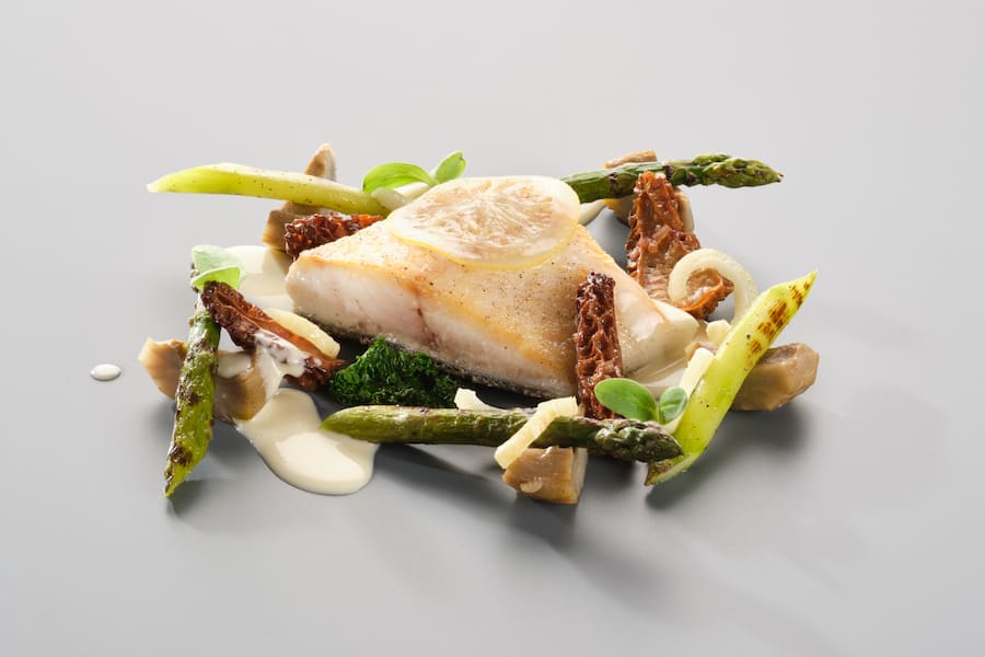 Wildfang Loup de mer mit eingelegter Zitrone Artischocken, Rheintaler Spargel, Morcheln aus der Surselva und Zitronengras-Velouté.