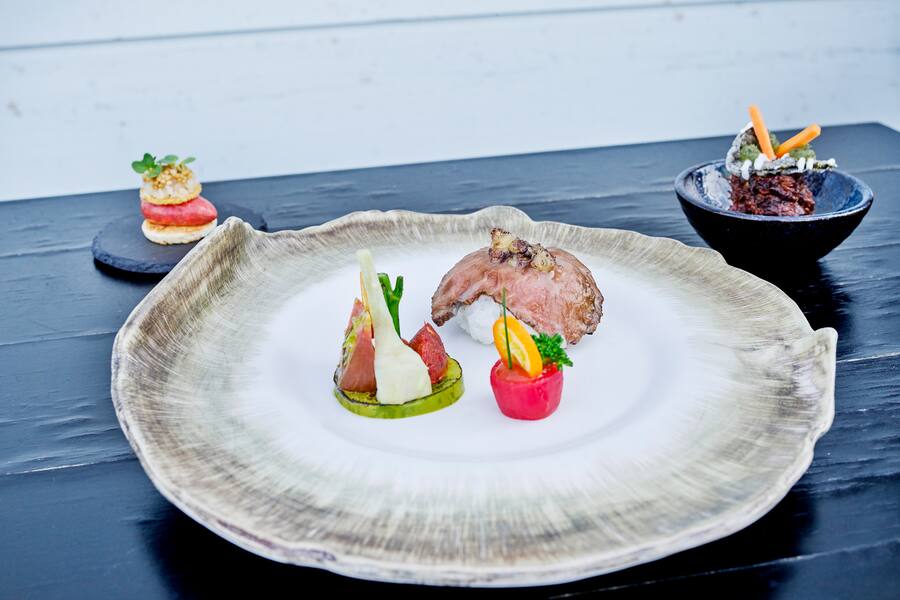 Entrecote von der alten Kuh Jasmin mit Soja-Koji, feines Tatar Americaine auf Brioche, Sushireis und Wachtelei, Tomaten und Kumquat, gepickelte Tulpenzwiebeln aus Holland, Sambal Badjak Chilimarmelade, geschmortes Voressen mit Reis und Creme Fraiche (Milchreis)