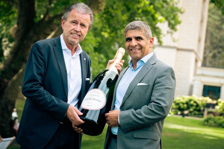 Zwei Männer mit einer grossen Champagnerflasche