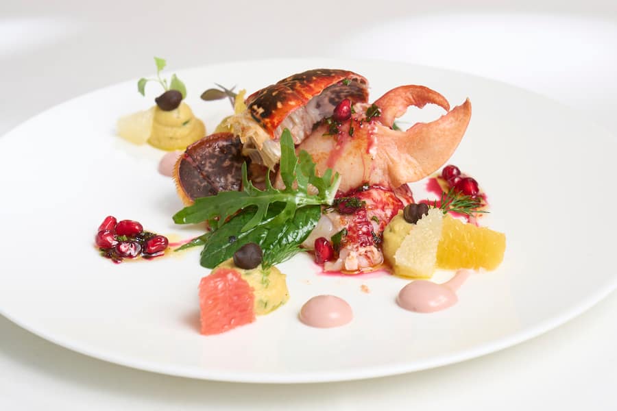 Hummersalat, Kichererbsen, Zitrusfrüchte, Granatapfel-Vinaigrette, Mesclunsalat. Bretonische Wochen bei Chef Denis Schmitt, Restaurant Le Murenberg, Bubendorf BL, 04.10.2023, Foto Lucia Hunziker / Ringier Axel Springer Schweiz