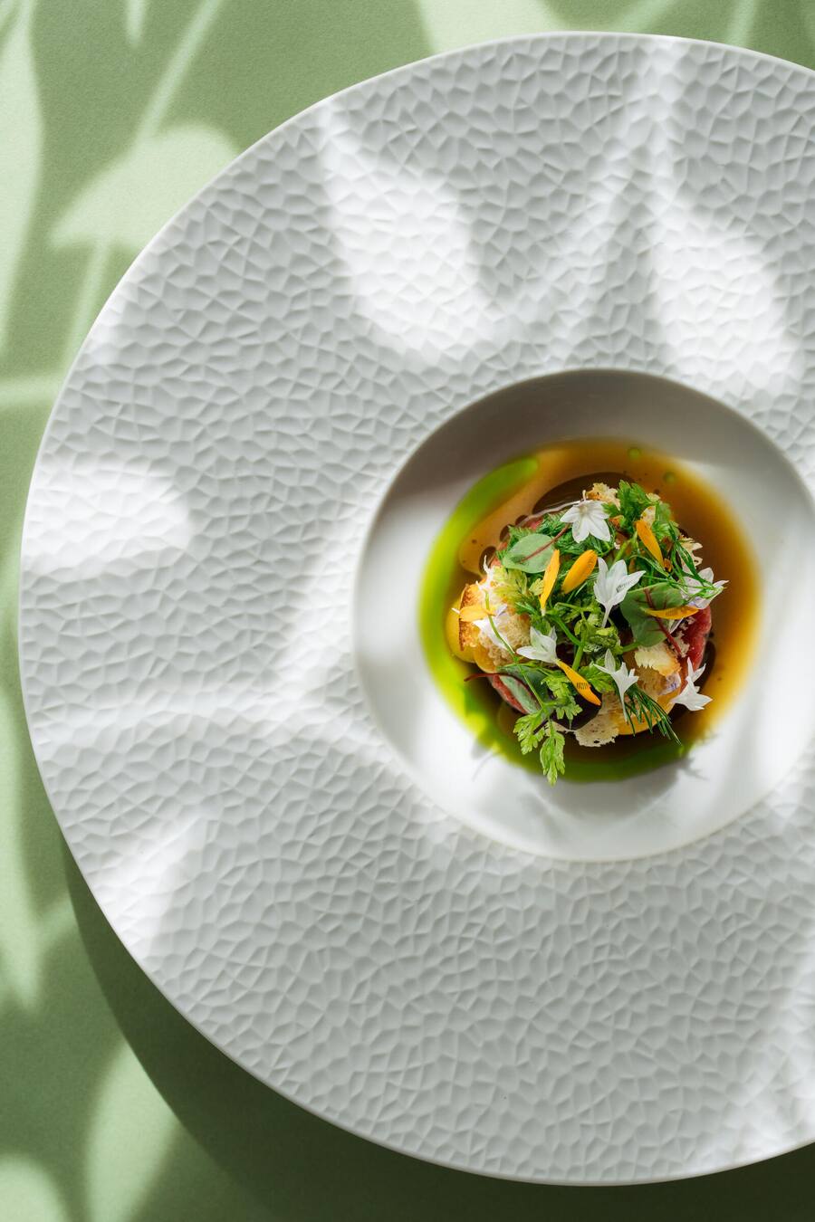 Wagyu Tatar Kalte Kräuter-Kraftbrühe | Eigelbereme | Schlottendl Gartenkräuter Brotchips - Jonas Ingold, Kuechenchef, Restaurant zum Löwen - Messen - 16. August 2023 - Copyright Olivia Pulver