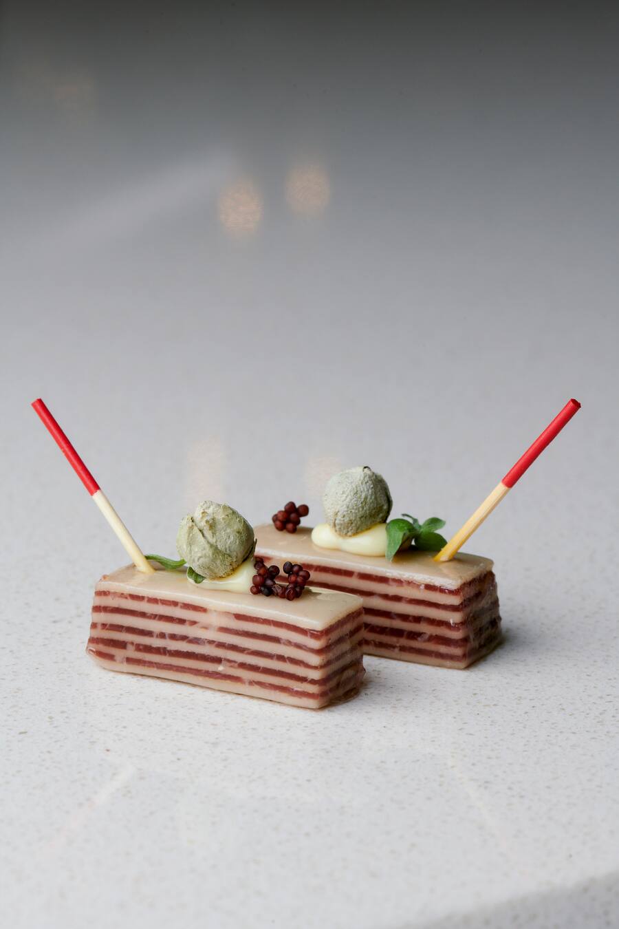 Carcenats Signature-Amuse bouche: Millefeuille mit Trockenfleisch und Käse aus der Region.