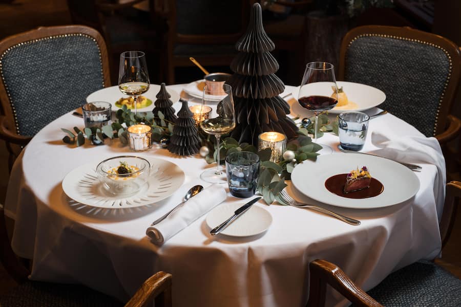 Mousse vom Bodensee Aal mit Kaviar und Eigelb - Getrüffelte Kartoffelgnocchi mit Schnittlauch Beurre blanc - Rosa gebratene Entenbrust mit Orangen-Pfeffersauce - Karamellisierter Bratapfel mit Zimt-Zabaione - Weihnachtsmenue von Stefan Jaeckel, Storchen Zuerich - November 2023 - Copyright Olivia Pulver