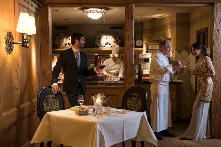 Young couple taking with Chef Franz Faeh in the dining room of Le Grill Restaurant at Gstaad Palace in Gstaad