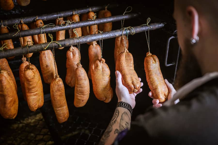 Le boucher Michaël Wyler confectionne des saucissons vaudois et des saucisses aux choux dans sa boucherie, mardi 12 décembre 2023 à Lucens. (© Gabriel Monnet)