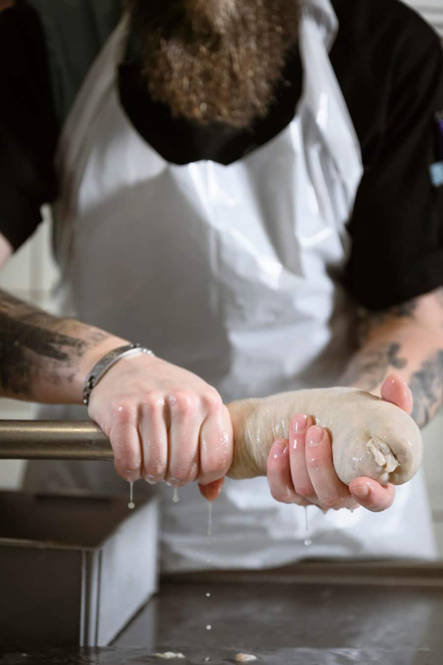 Le boucher Michaël Wyler confectionne des saucissons vaudois avec son employé dans sa boucherie, mardi 12 décembre 2023 à Lucens. (© Gabriel Monnet)