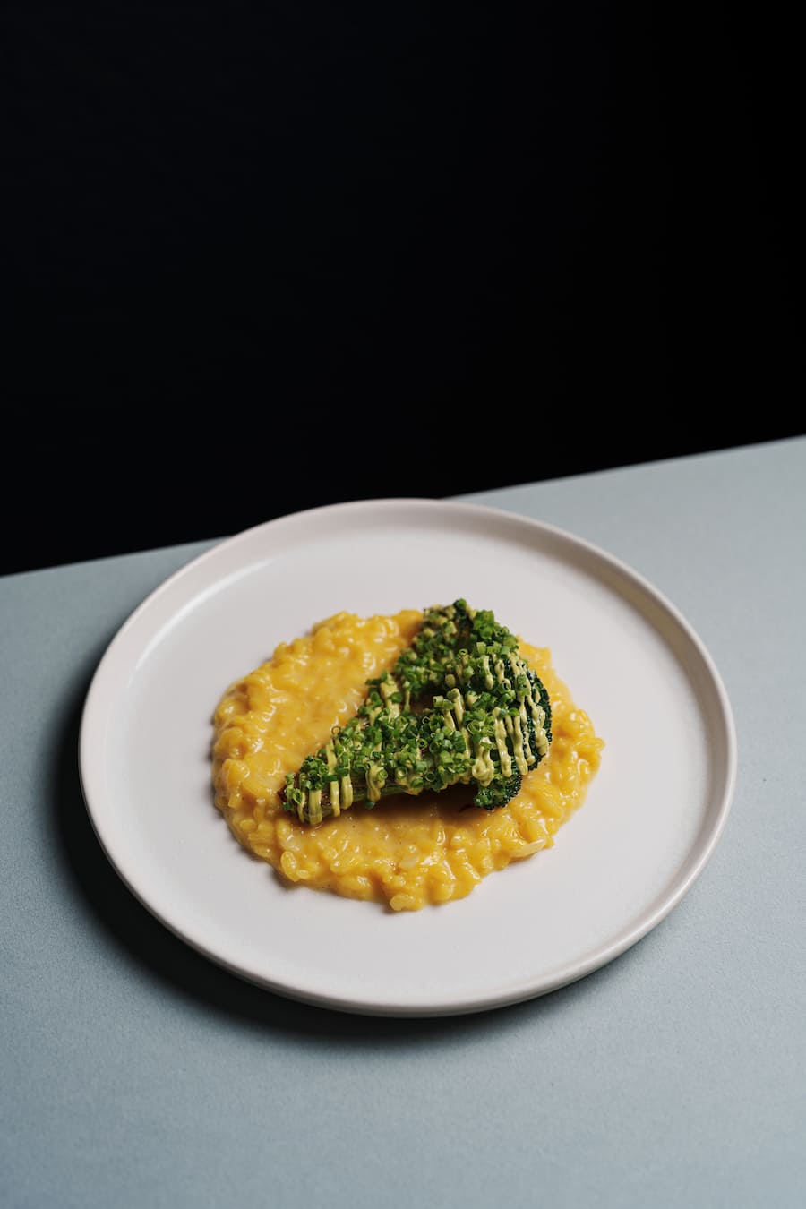 Zitronen-Safran Risotto, mit dem grillierten Brokkoli, dazu Schnittlauchcreme und frischer Schnittlauch - Ameo Zuerich - Kuechenchef Julien Mühlebach - Gastgeber Maximilian Dullinger - Januar 2024 - Copyright Olivia Pulver